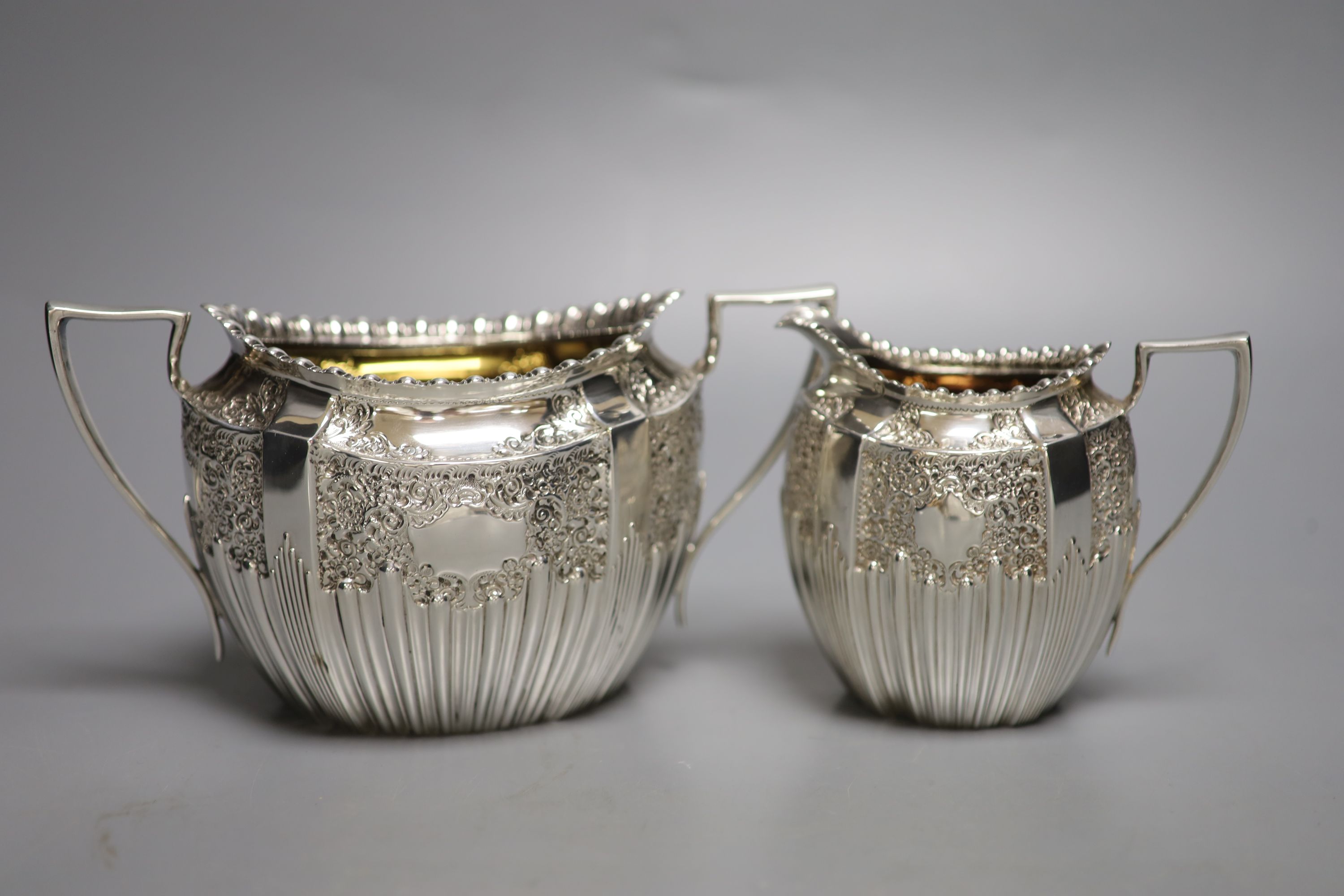A late Victorian embossed silver sugar bowl and cream jug, James Dixon & Sons, Sheffield, 1896/7,